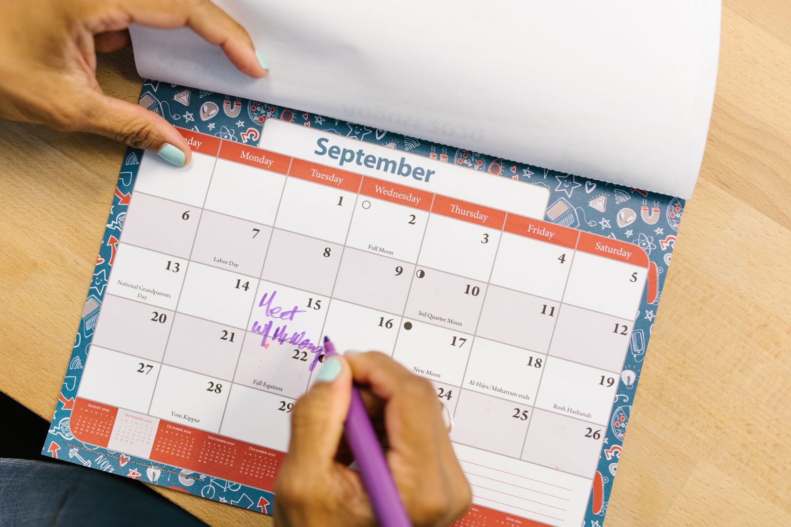 Personne qui note un rendez-vous sur un calendrier papier